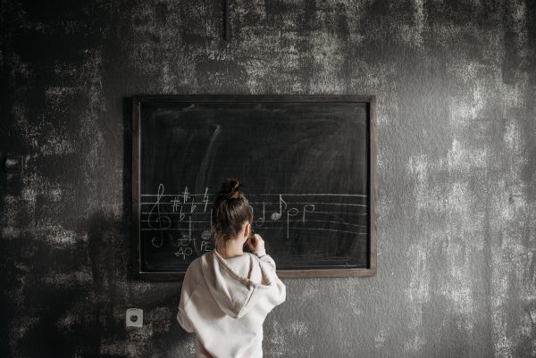 Mokinės rašančios natas lentynoje nuotrauka
